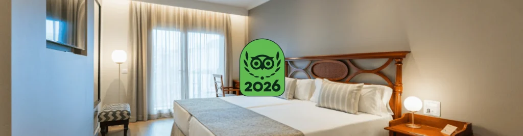 Hotel Rever&oacute;n Plaza en Los Cristianos, Tenerife, con un logotipo superpuesto que indica el premio Travelers' Choice de TripAdvisor de 2026.