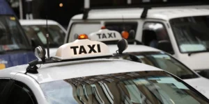 Taxi vehicles with a luminous sign on the roof ready for service.