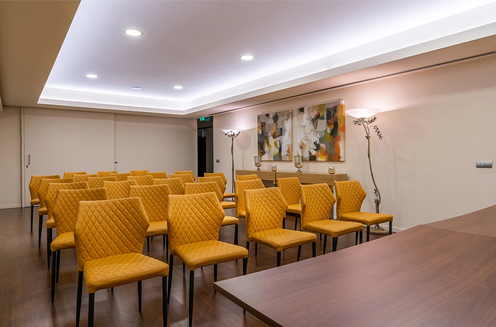 Sala de confer&ecirc;ncia com cadeiras vazias e decora&ccedil;&atilde;o moderna.