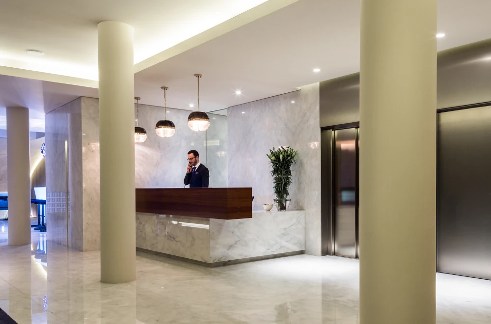 Recep&ccedil;&atilde;o de hotel moderna com atendente ao telefone.