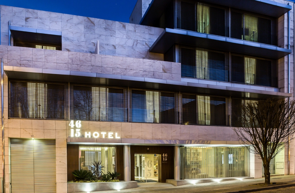 Fachada moderna de hotel iluminada &agrave; noite com n&uacute;meros 46 e 15 vis&iacute;veis.