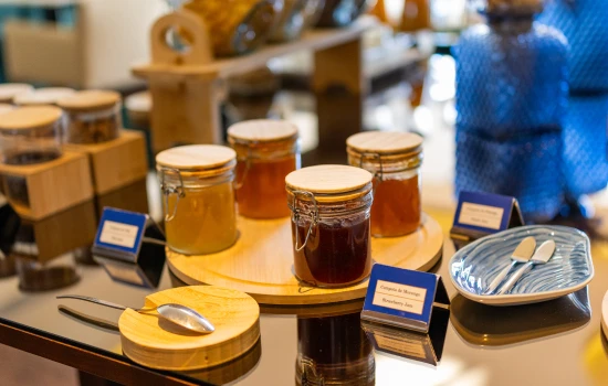 Potes de geleia em mesa com utens&iacute;lios e placas de identifica&ccedil;&atilde;o.