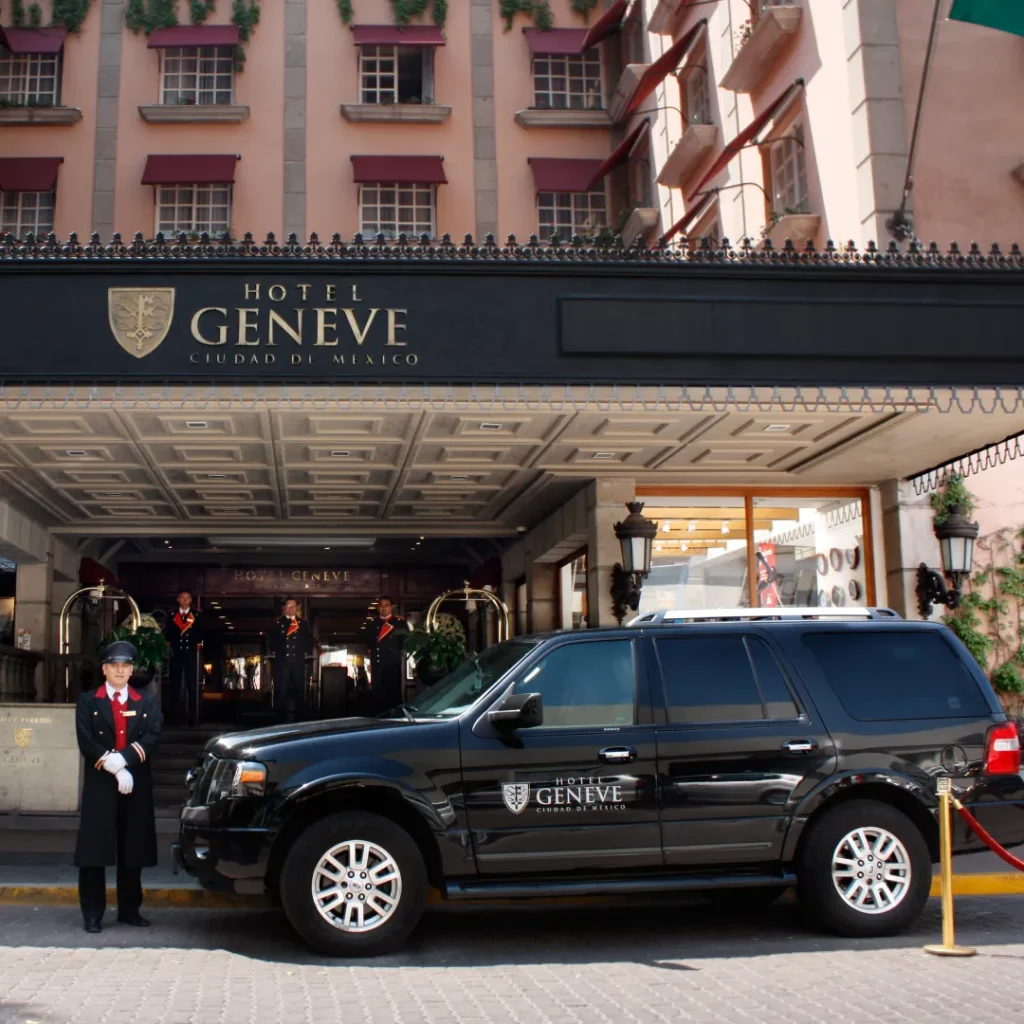 Entrada del Hotel Geneve en Ciudad de M&eacute;xico con un auto negro estacionado y personal del hotel en la entrada.