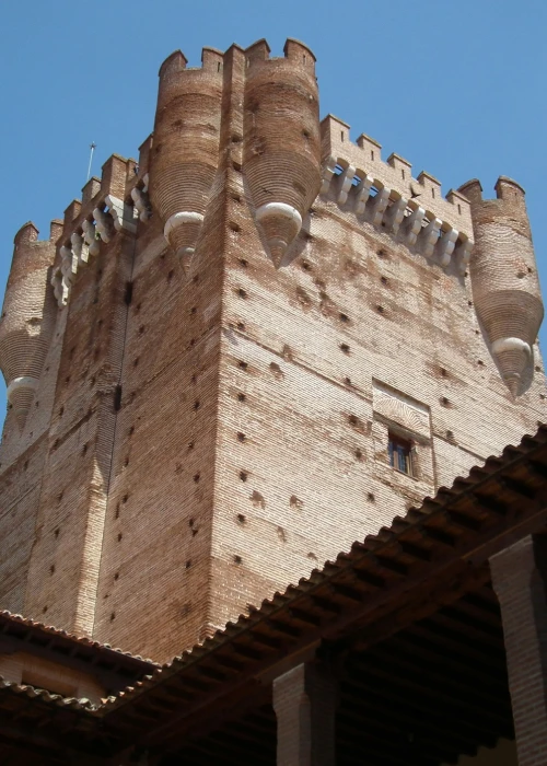 Torre de castillo de ladrillo marrón bajo cielo azul claro.