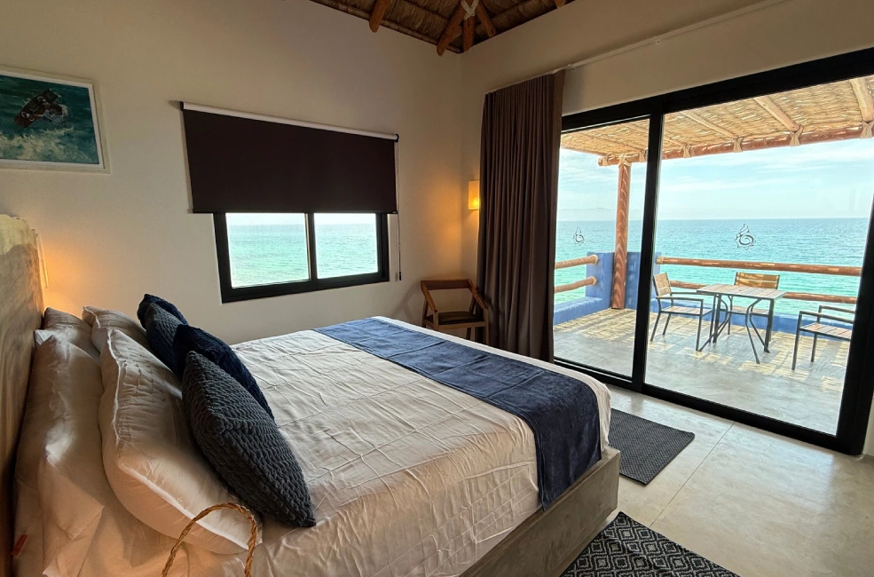 Habitaci&oacute;n con cama y balc&oacute;n frente al mar.