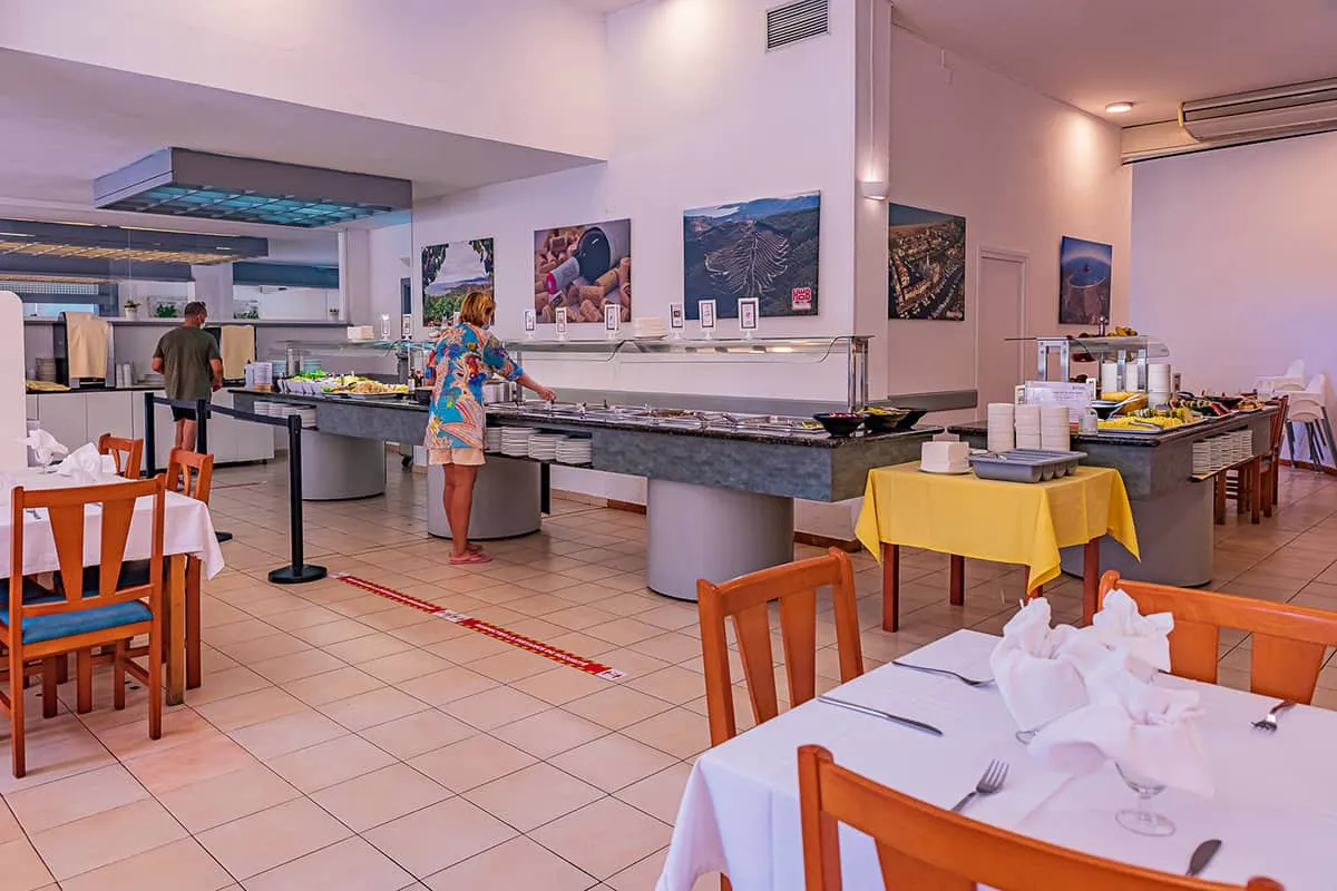 Buffet en restaurante con clientes sirvi&eacute;ndose comida.