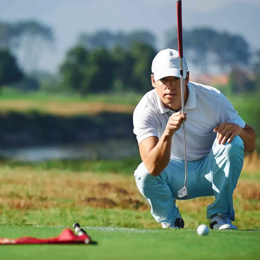 Hombre mide putt de golf en campo verde, d&iacute;a soleado.