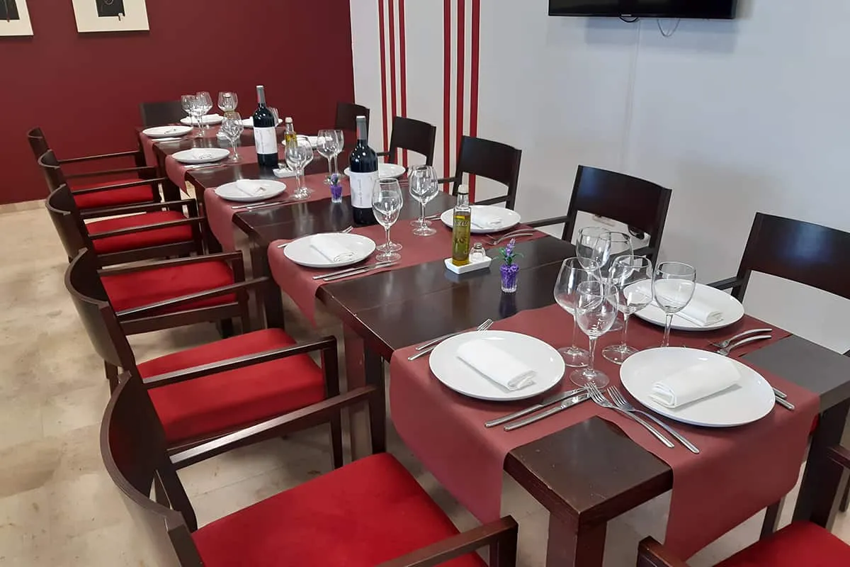 Mesa puesta con copas y platos en un comedor elegante.