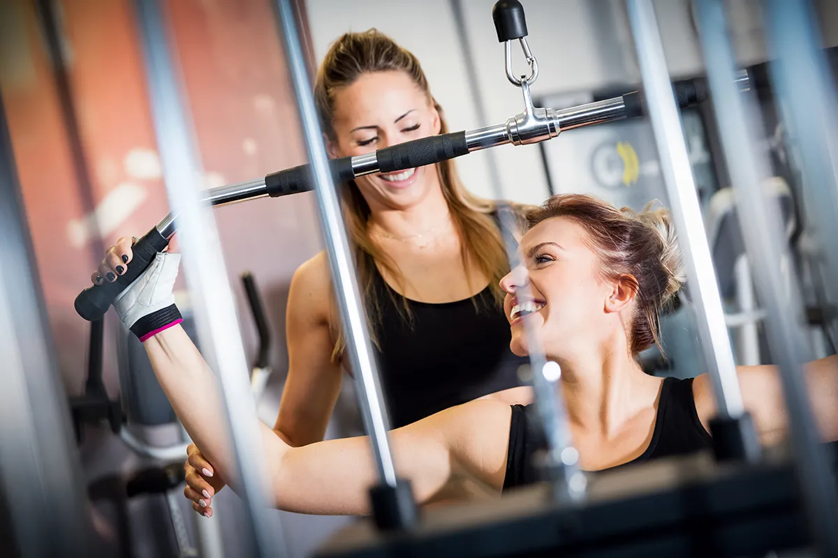 Mujeres riendo mientras entrenan en el gimnasio.