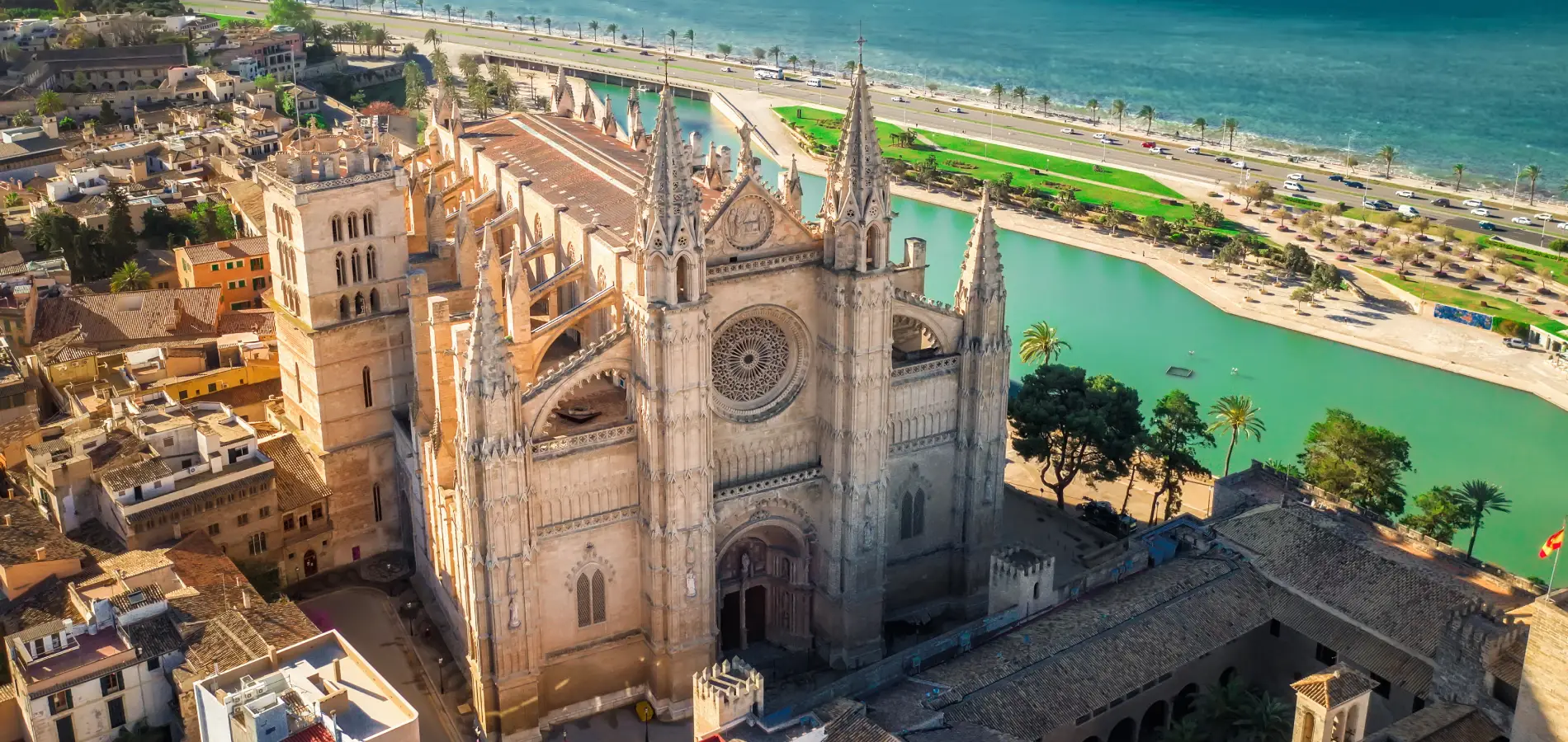 Catedral g&oacute;tica junto al mar en una ciudad, rodeada de edificios y un lago.