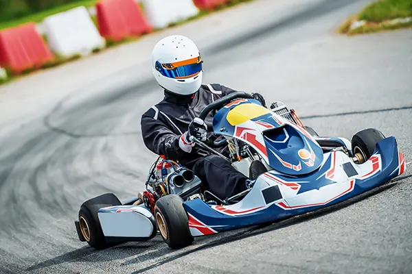 Persona conduciendo un kart en una pista de carreras.