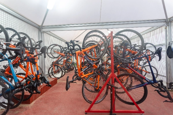 Bicicletas naranjas y azules colgadas en un almac&eacute;n iluminado.