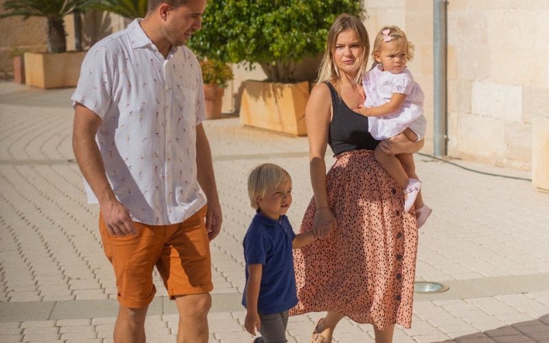 Familia paseando por la calle en un d&iacute;a soleado.