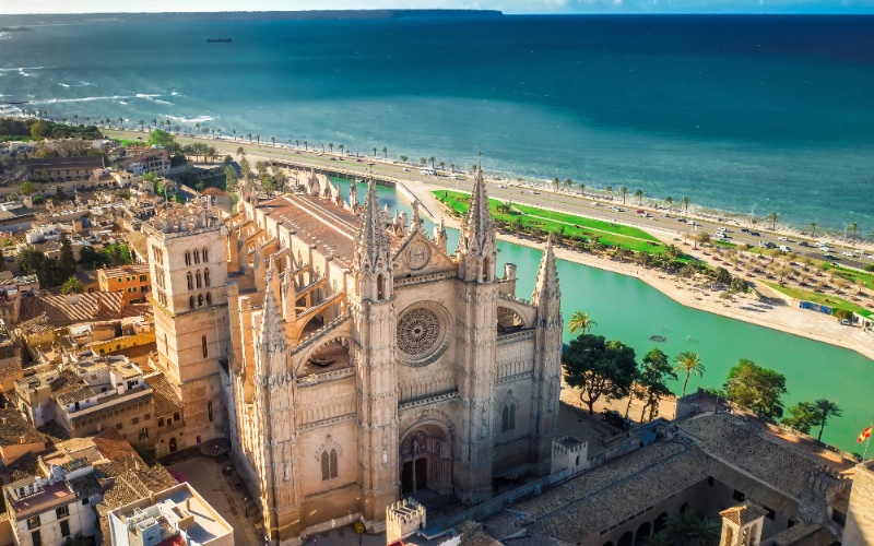 Catedral g&oacute;tica junto al mar y ciudad con vista a&eacute;rea.