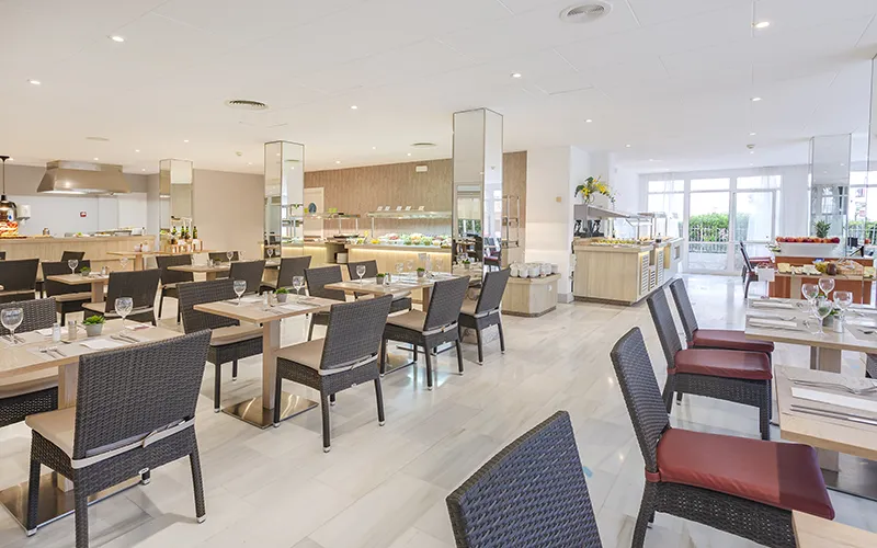 Restaurante moderno con mesas y sillas dispuestas para comensales.