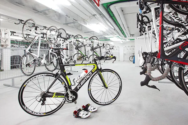 Sala de almacenamiento con bicicletas colgadas y una en primer plano.