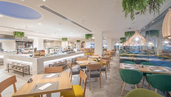 Restaurante moderno con mesas de madera y decoraci&oacute;n luminosa.