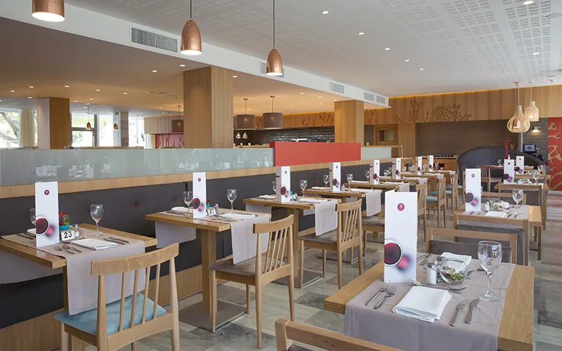 Restaurante moderno con mesas preparadas y decoraci&oacute;n de madera.