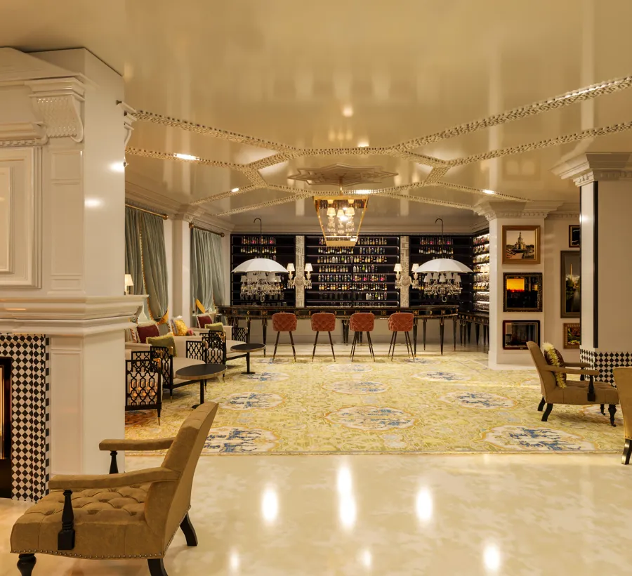 Un elegante bar con sillas de cuero y l&aacute;mparas colgantes en el techo.