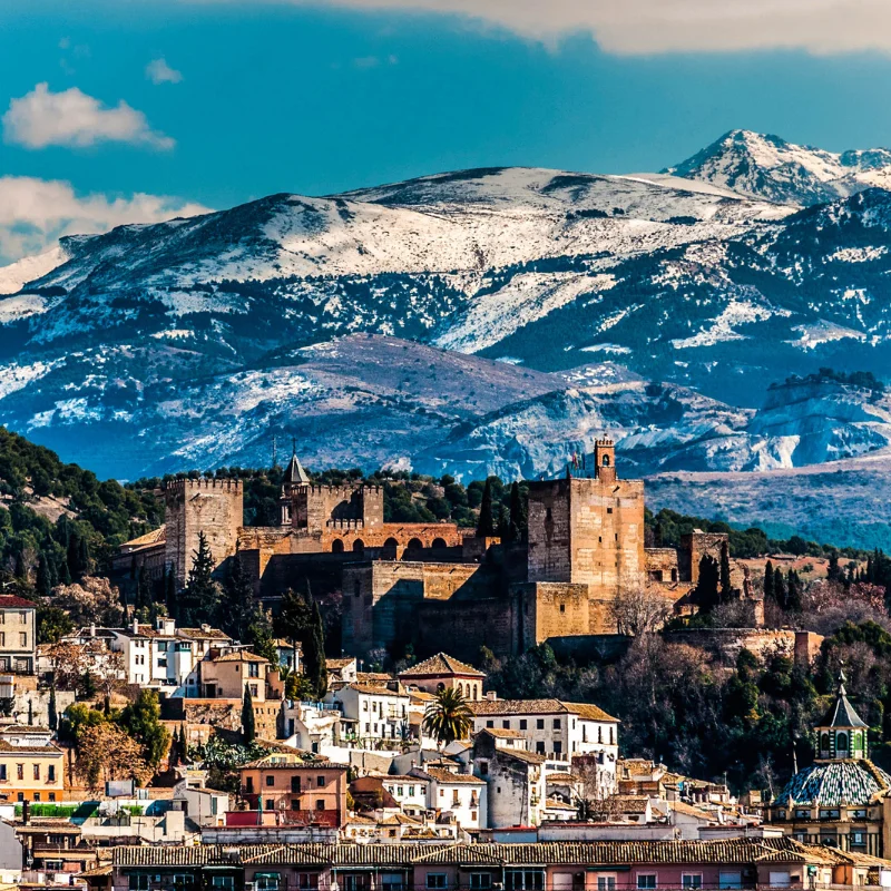 Vista de la Alhambra en Granada con monta&ntilde;as nevadas al fondo.
