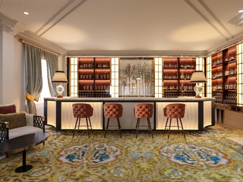 Bar elegante con sillas acolchadas y estanter&iacute;as iluminadas.