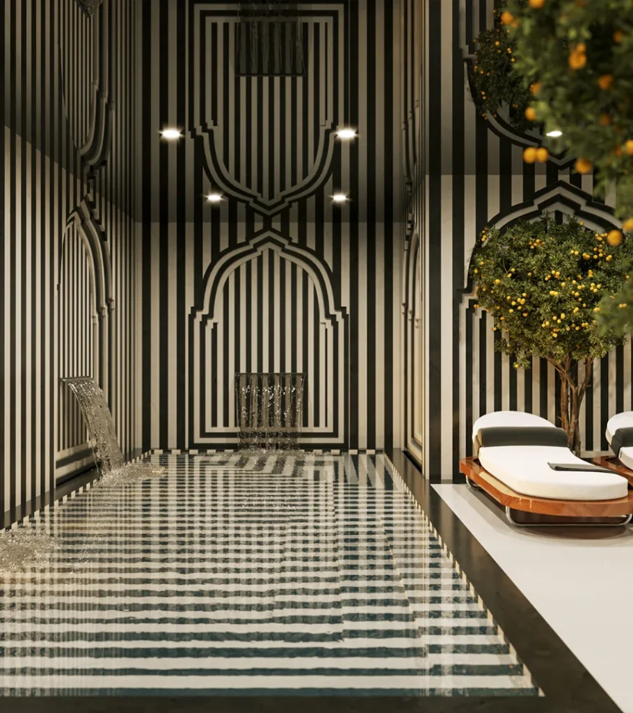 Piscina interior con paredes de rayas blancas y negras, dos camastros y un &aacute;rbol.