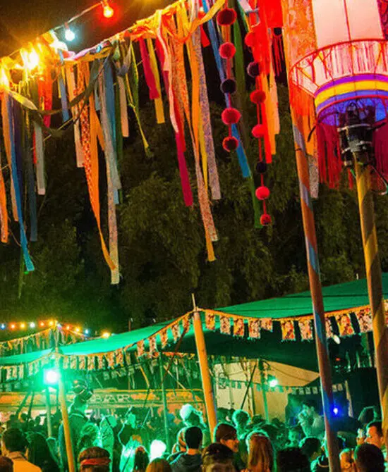 Festival nocturno con luces coloridas y decoraciones vibrantes.