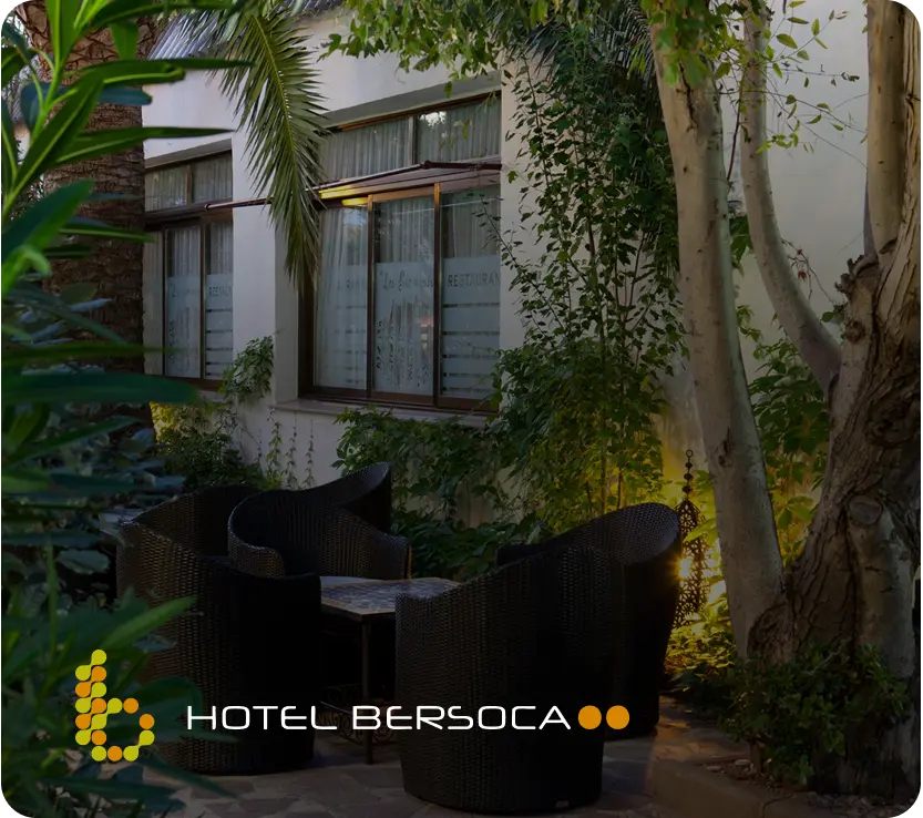 Terraza al aire libre con sillas y vegetación en Hotel Bersoca.