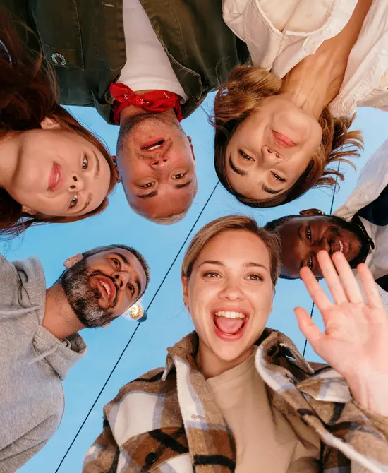 Grupo de seis personas sonrientes mirando a la cámara desde abajo.