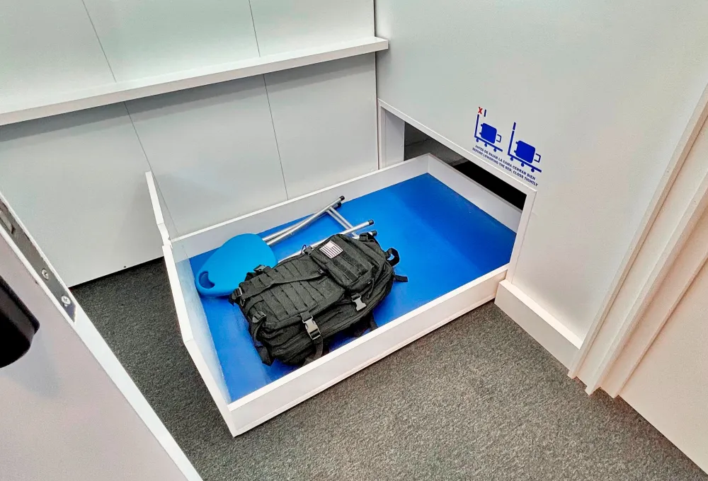 Caja de medici&oacute;n con mochila y bastones en su interior.