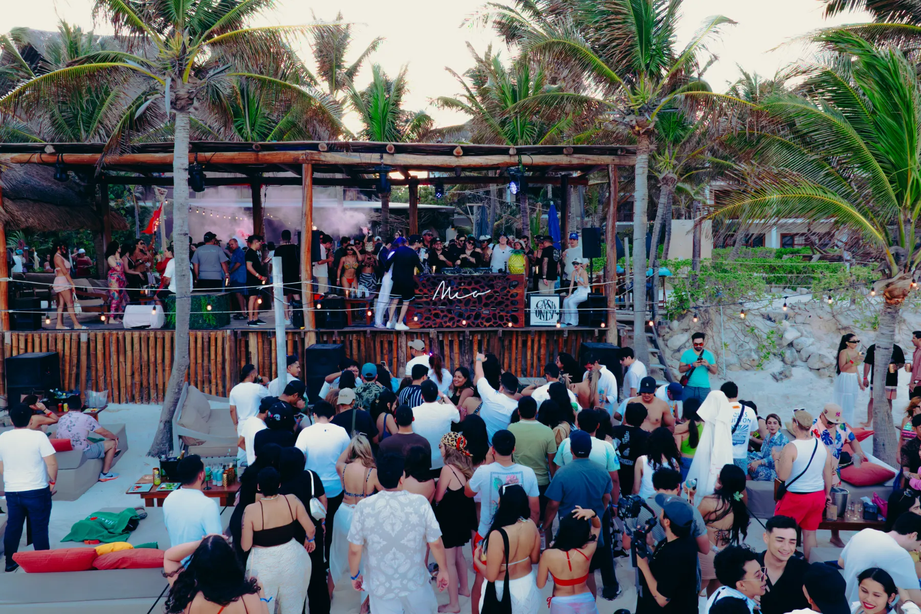 Grupo de personas bailando en una fiesta junto a la playa.