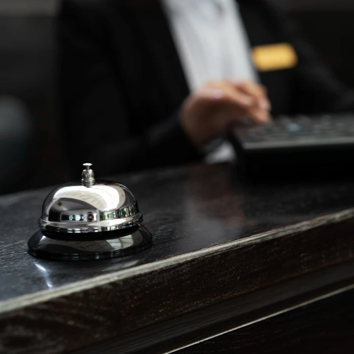 Cloche de réception argentée sur un comptoir sombre avec une personne en arrière-plan.