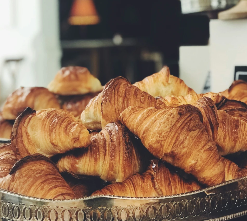 Des croissants empilés sur un plateau argenté.