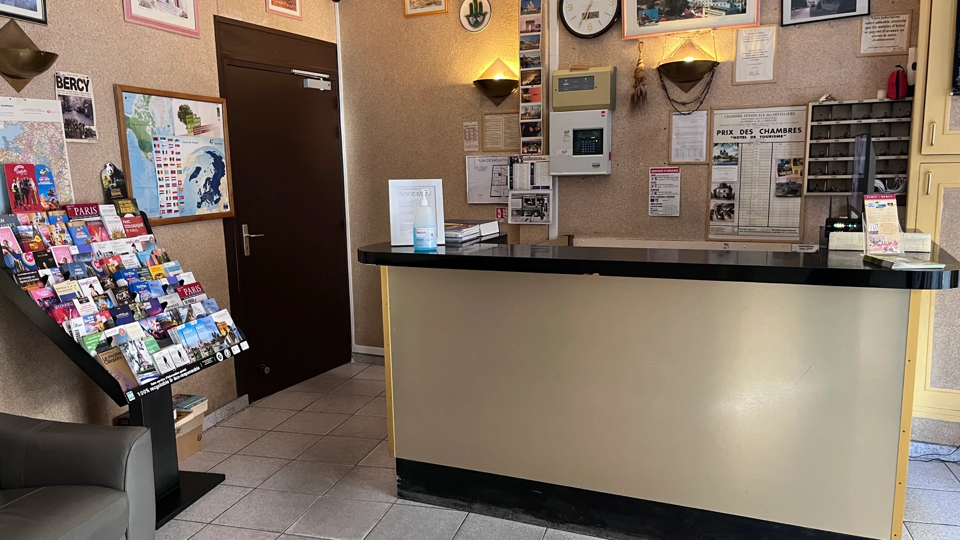 Réception d'un hôtel avec brochures touristiques sur un présentoir.
