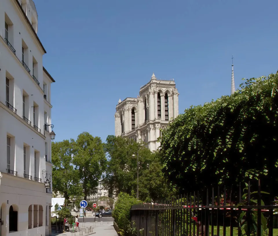 Edificio histórico con jardín y cielo azul.