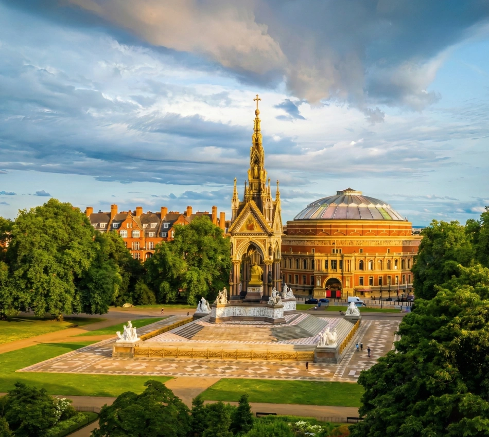 Sunny view of Victorian memorial and round building with trees.