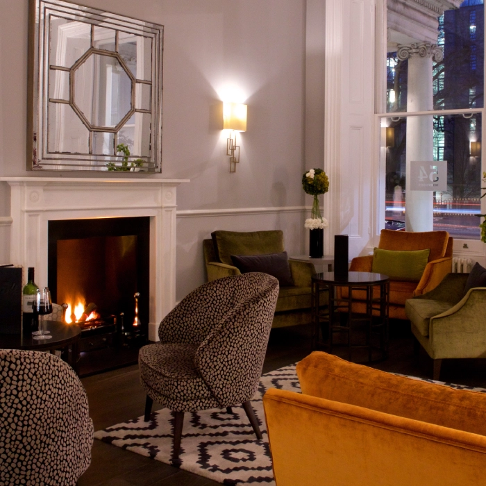 Stylish lounge with armchairs, fireplace, and decorative mirror.