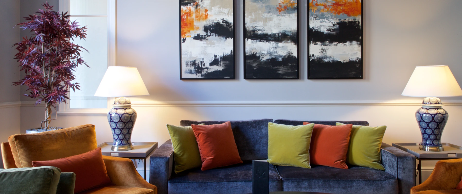 Cozy living room with colorful pillows and abstract art.