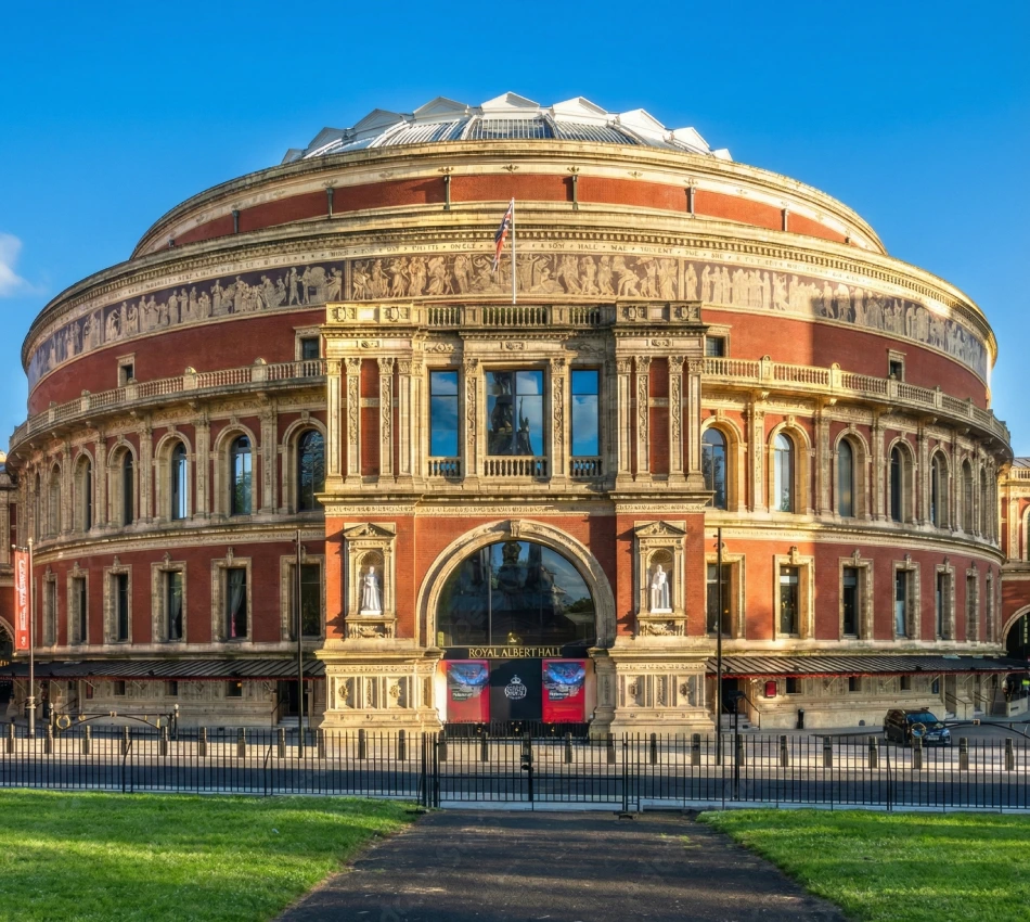 Large, round concert hall with ornate architecture and blue sky.