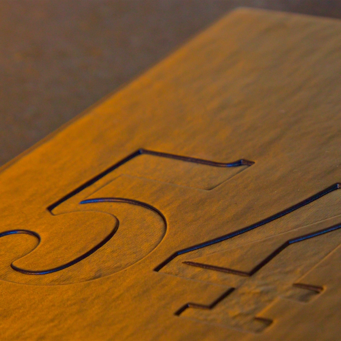 Close-up of the number "54" engraved on a metal surface.