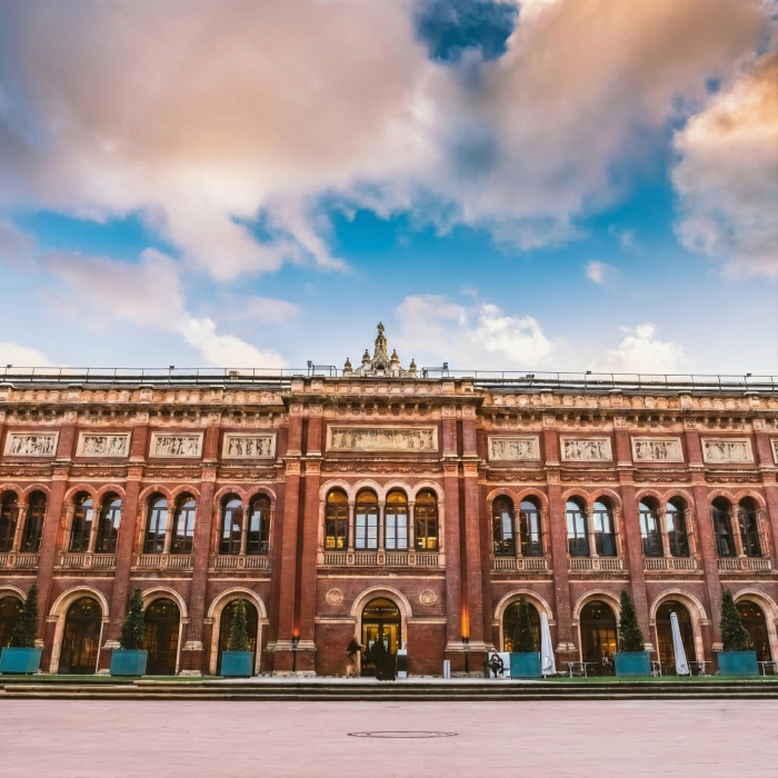Victorian red-brick building with a cloudy sky above.