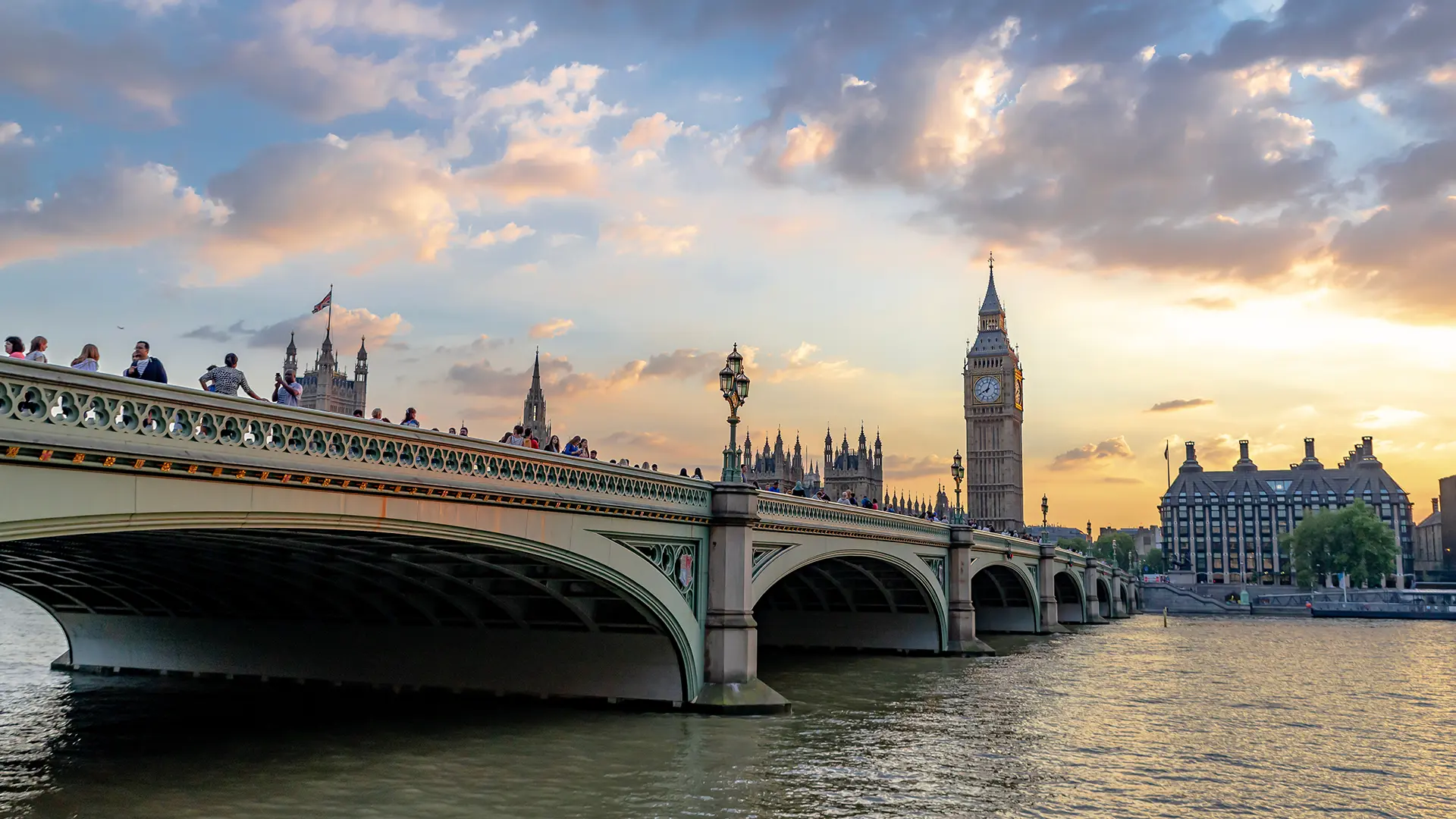 Westminster Bridge and Big Ben at sunset with cloudy skies.