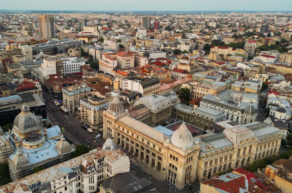 Aerial view of a historic city with domed buildings and a dense urban layout.