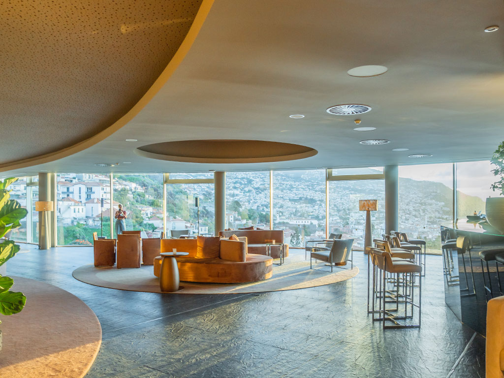 Modern lounge with panoramic windows overlooking a scenic mountain view.