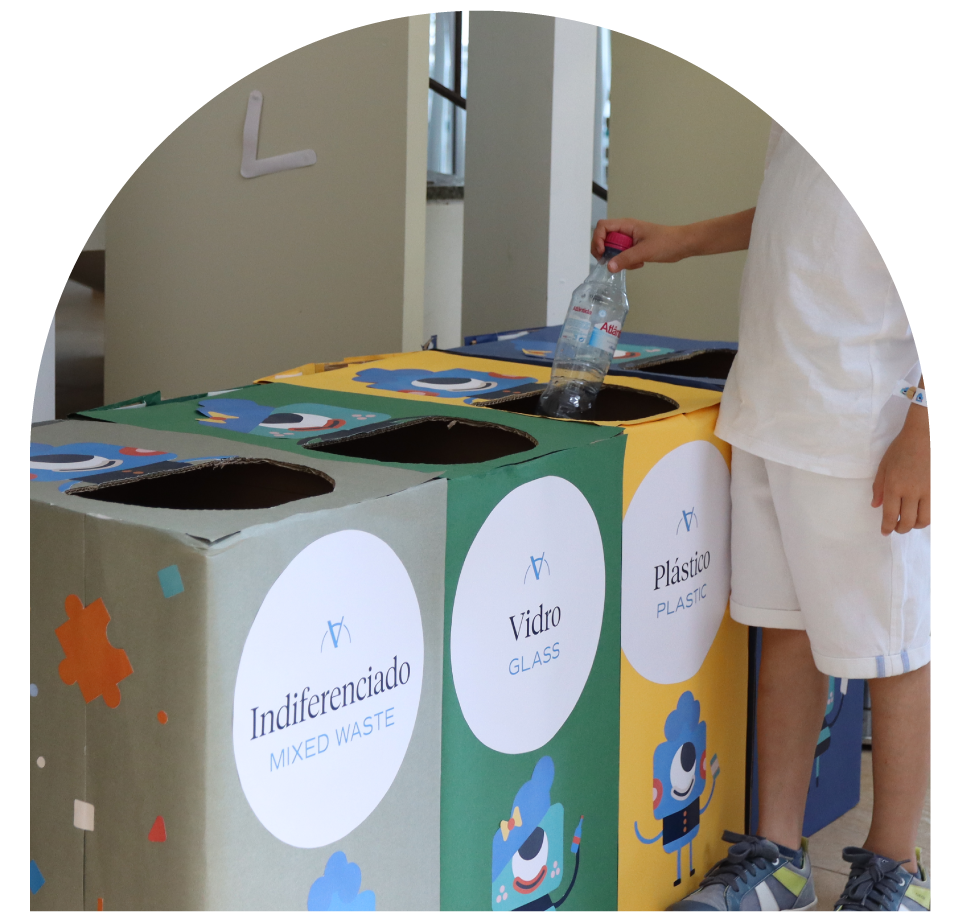 Child recycling a plastic bottle in labeled bins: Mixed Waste, Glass, Plastic.