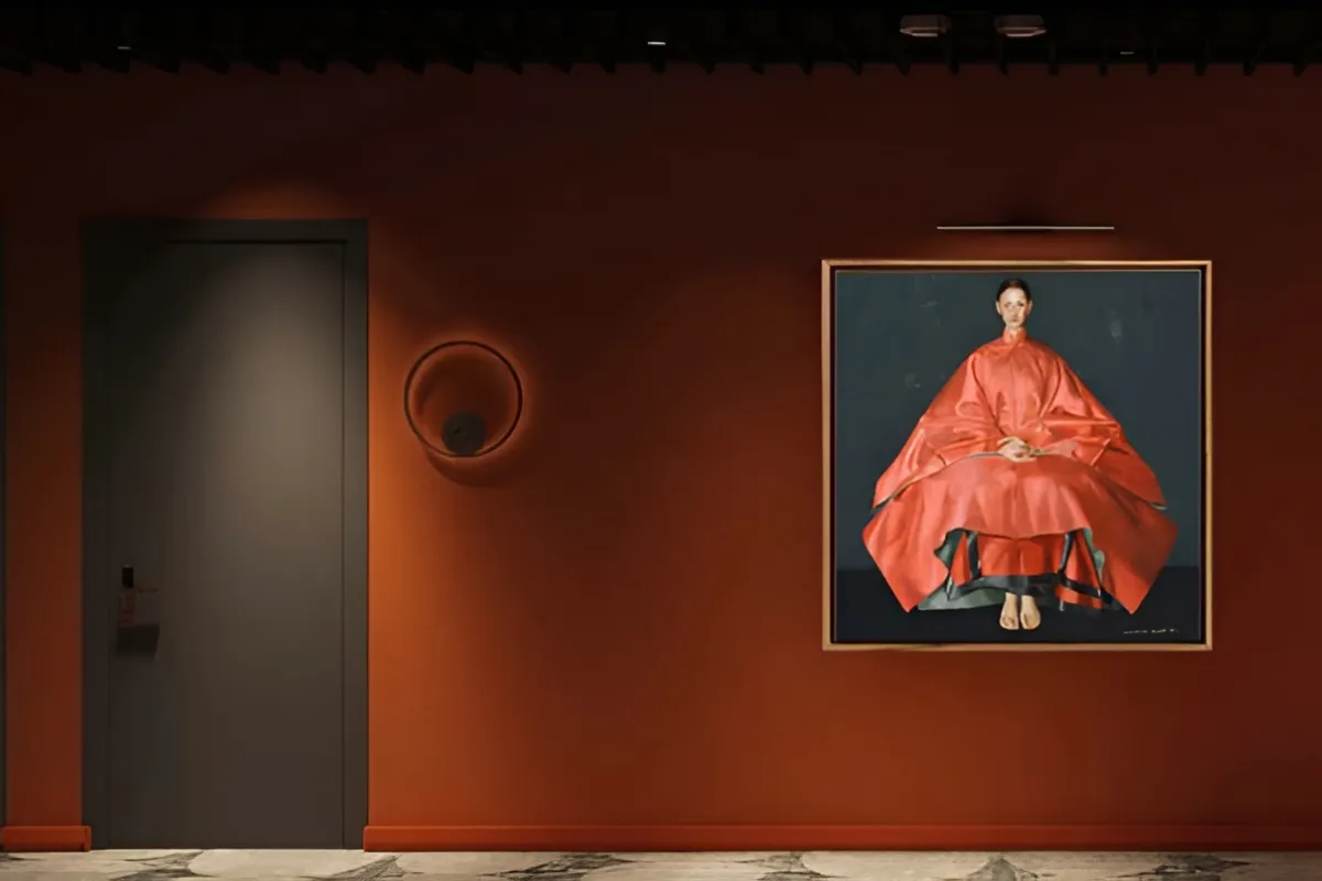 Hallway with an orange wall and a portrait of a woman in a red outfit.