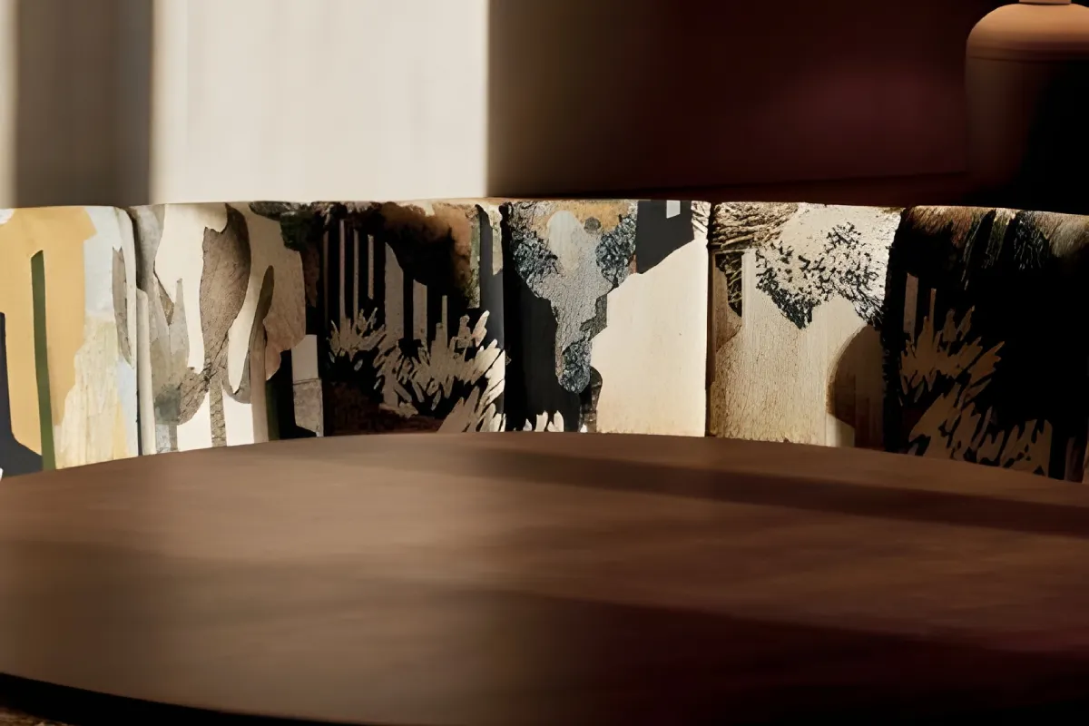 Wooden table with abstract-patterned curved chair in sunlight.
