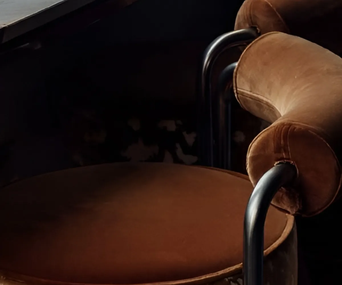Brown cushioned chairs with metal armrests in dim lighting.