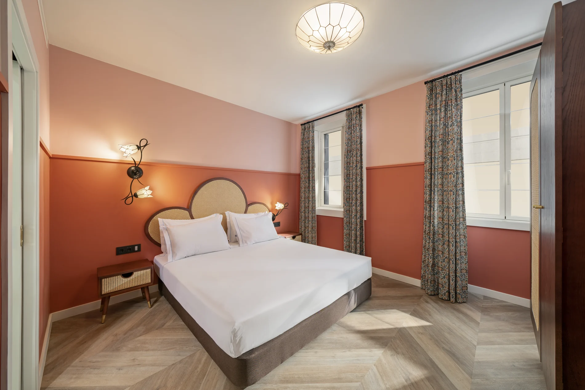 Stylish bedroom with pink walls and a large bed.