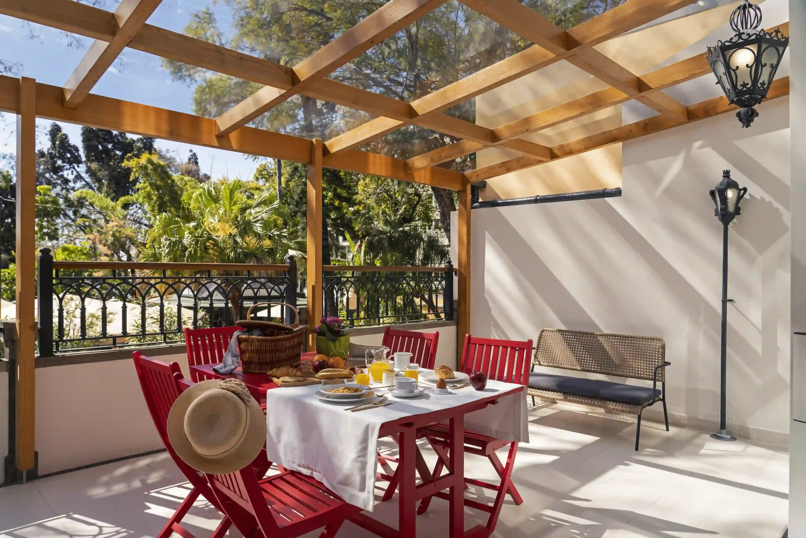 Outdoor patio with red chairs and table set for breakfast.